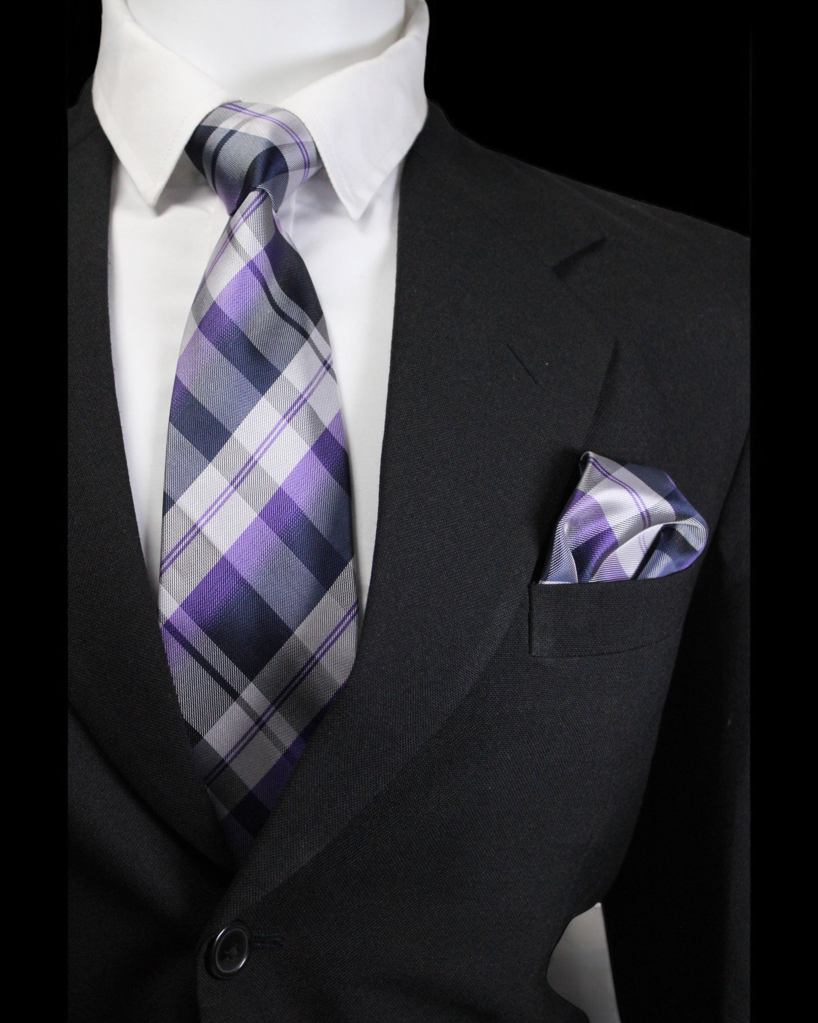 Black suit with a plaid purple and gray tie and matching pocket square.