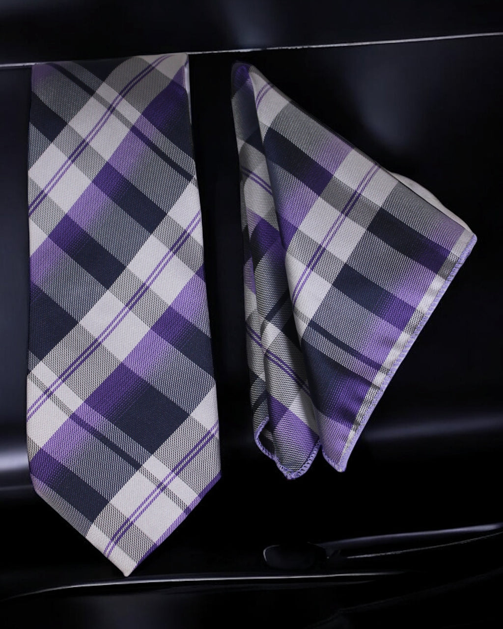 Plaid tie and pocket square set on a black background