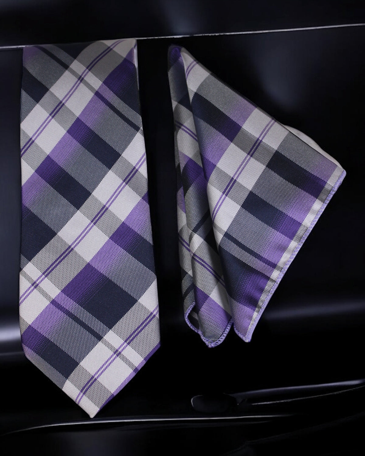 Plaid tie and pocket square set on a black background