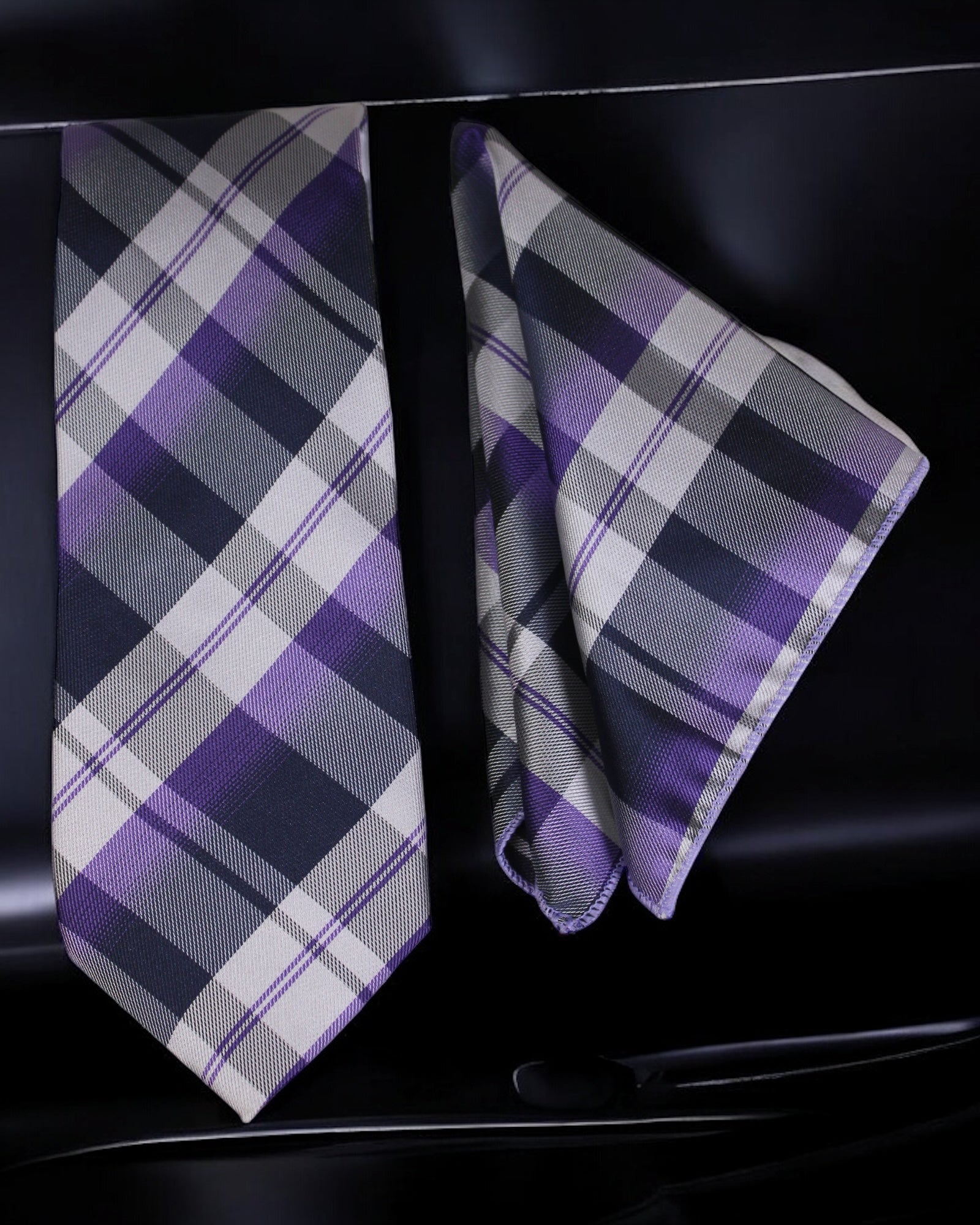 Plaid tie and pocket square set on a black background