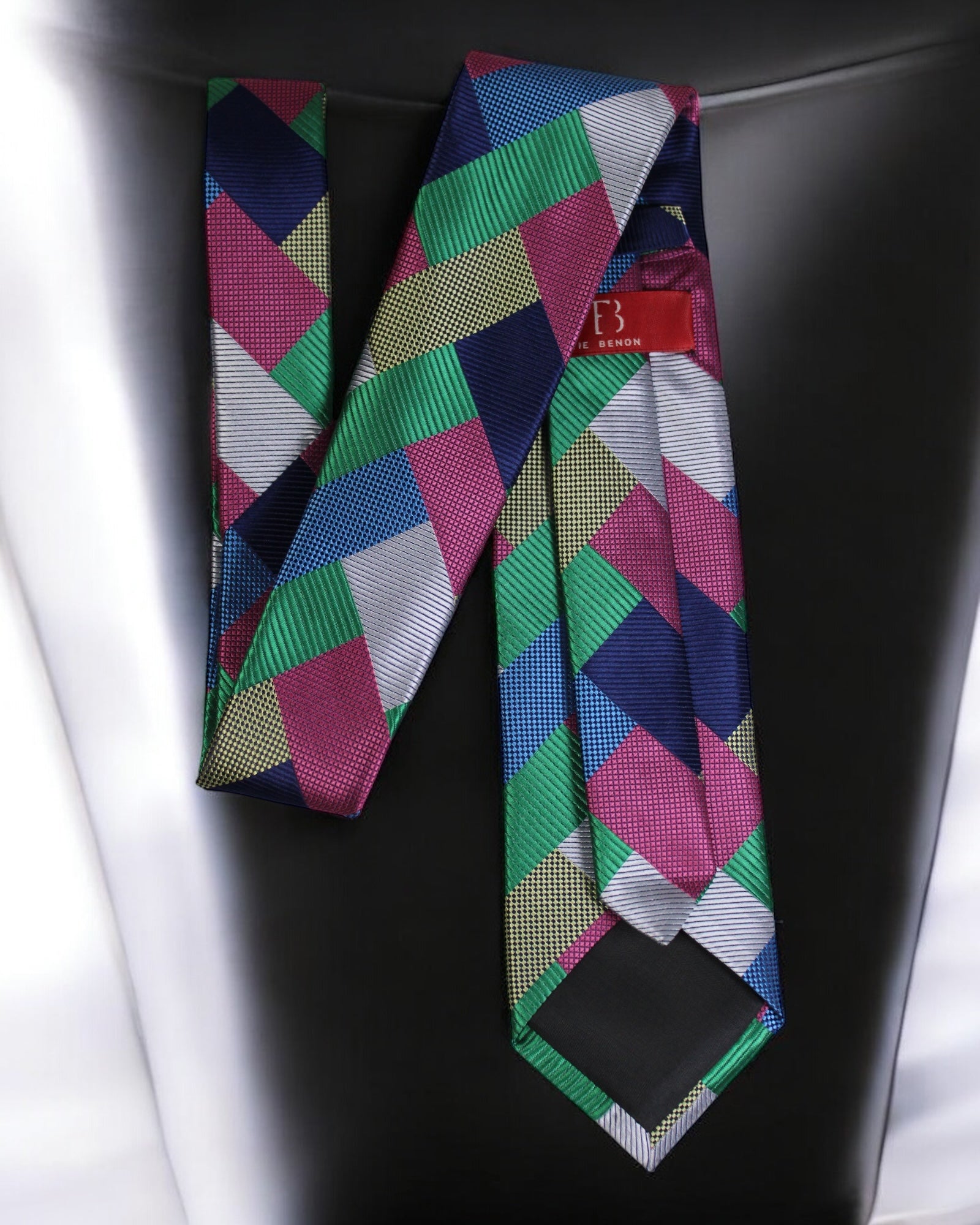 Colorful geometric patterned tie on a black surface Tie Benon