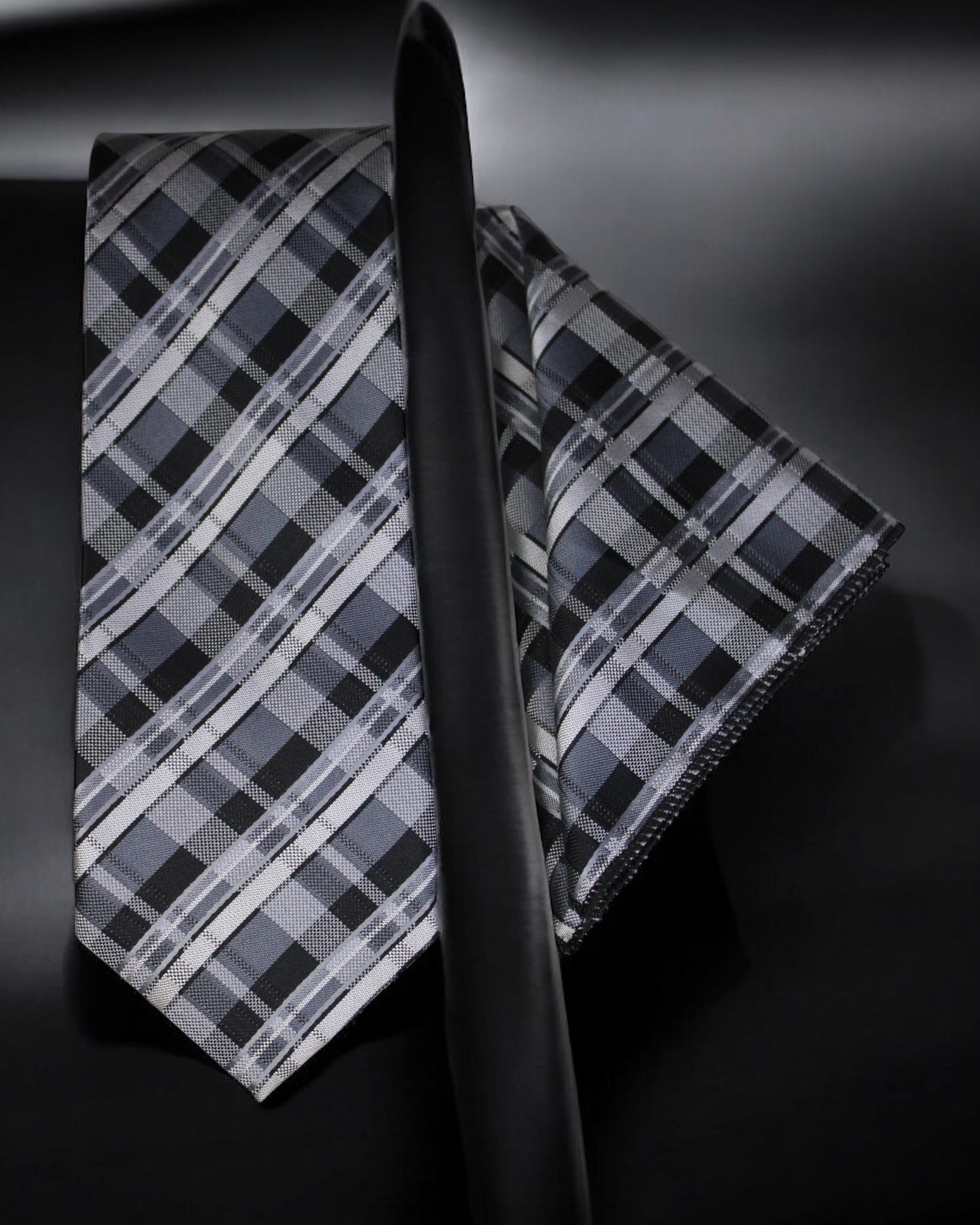 Plaid tie and matching pocket square on a black background
