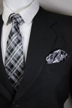 Close-up of a black suit jacket with a plaid pocket square and white shirt.