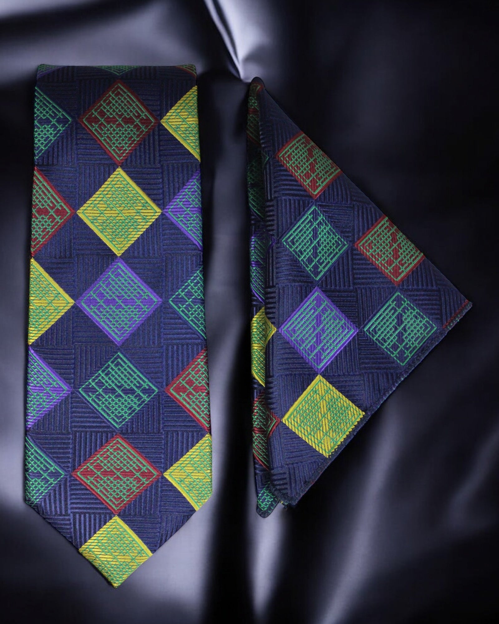 Colorful geometric patterned tie and pocket square on a dark fabric background Tie Benon