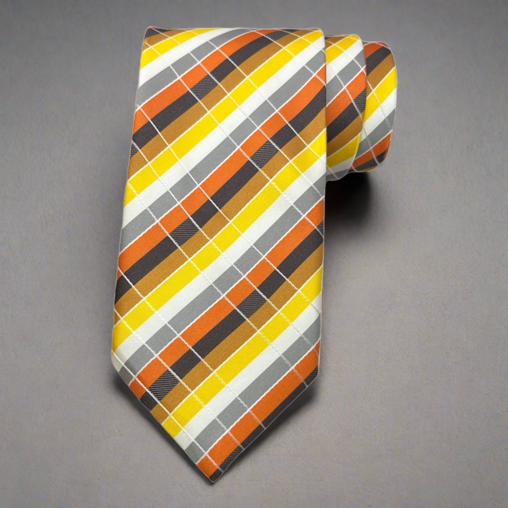 A striped necktie with yellow and orange plaid pattern, tied in a classic knot, displayed on a grey background.