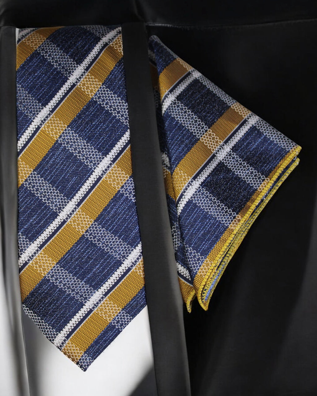 Blue and yellow striped tie with matching pocket square on a black background Tie Benon
