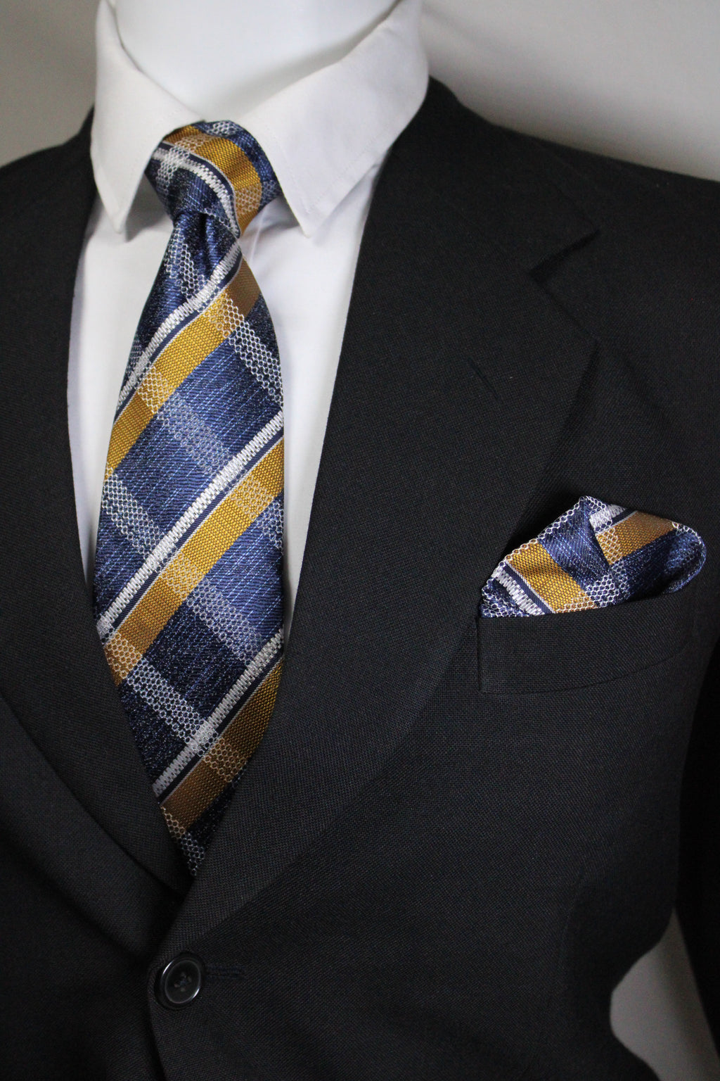 Striped tie hanging out of a suit pocket with a white shirt underneath Tie Benon