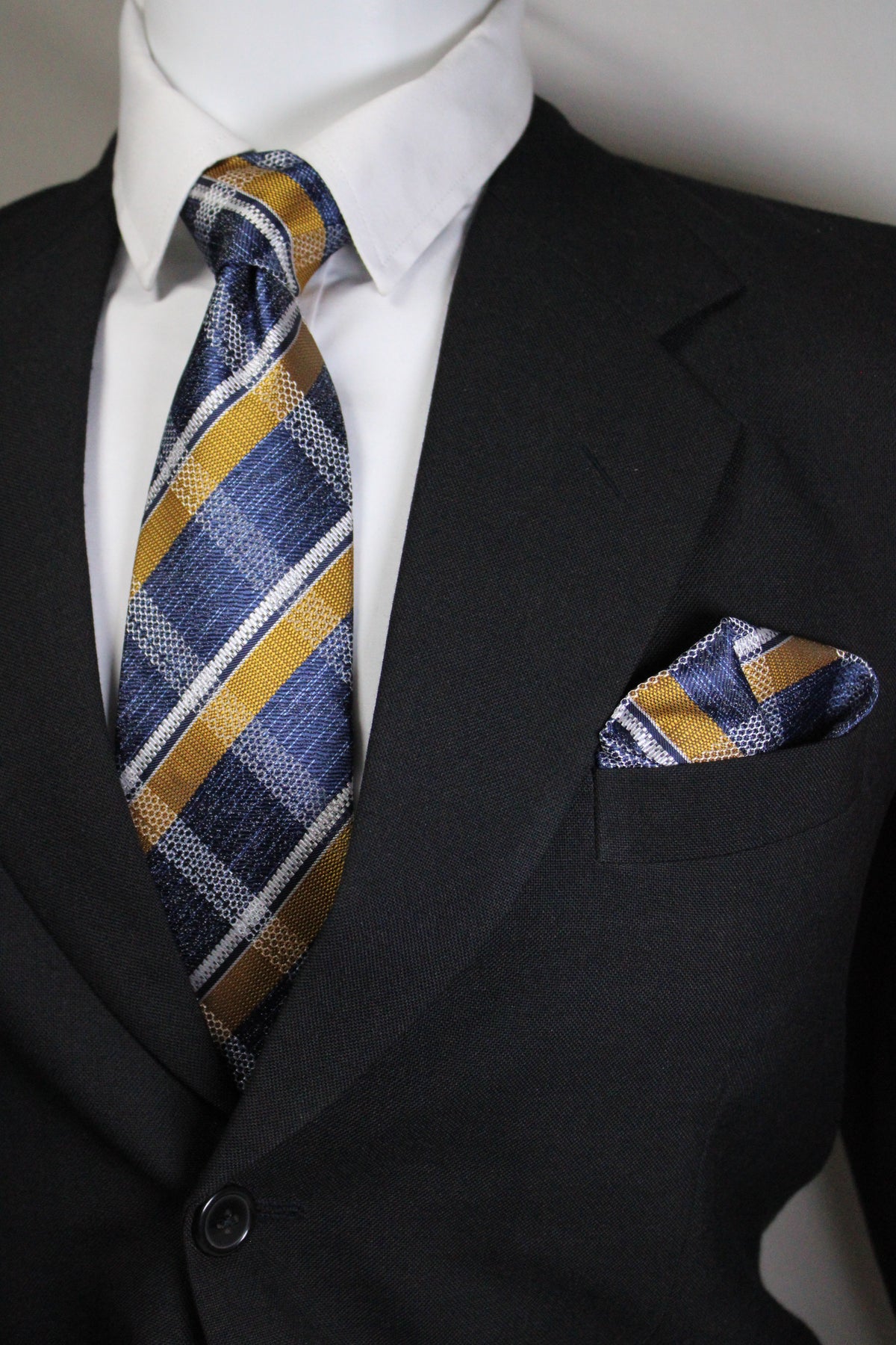 Striped tie hanging out of a suit pocket with a white shirt underneath Tie Benon