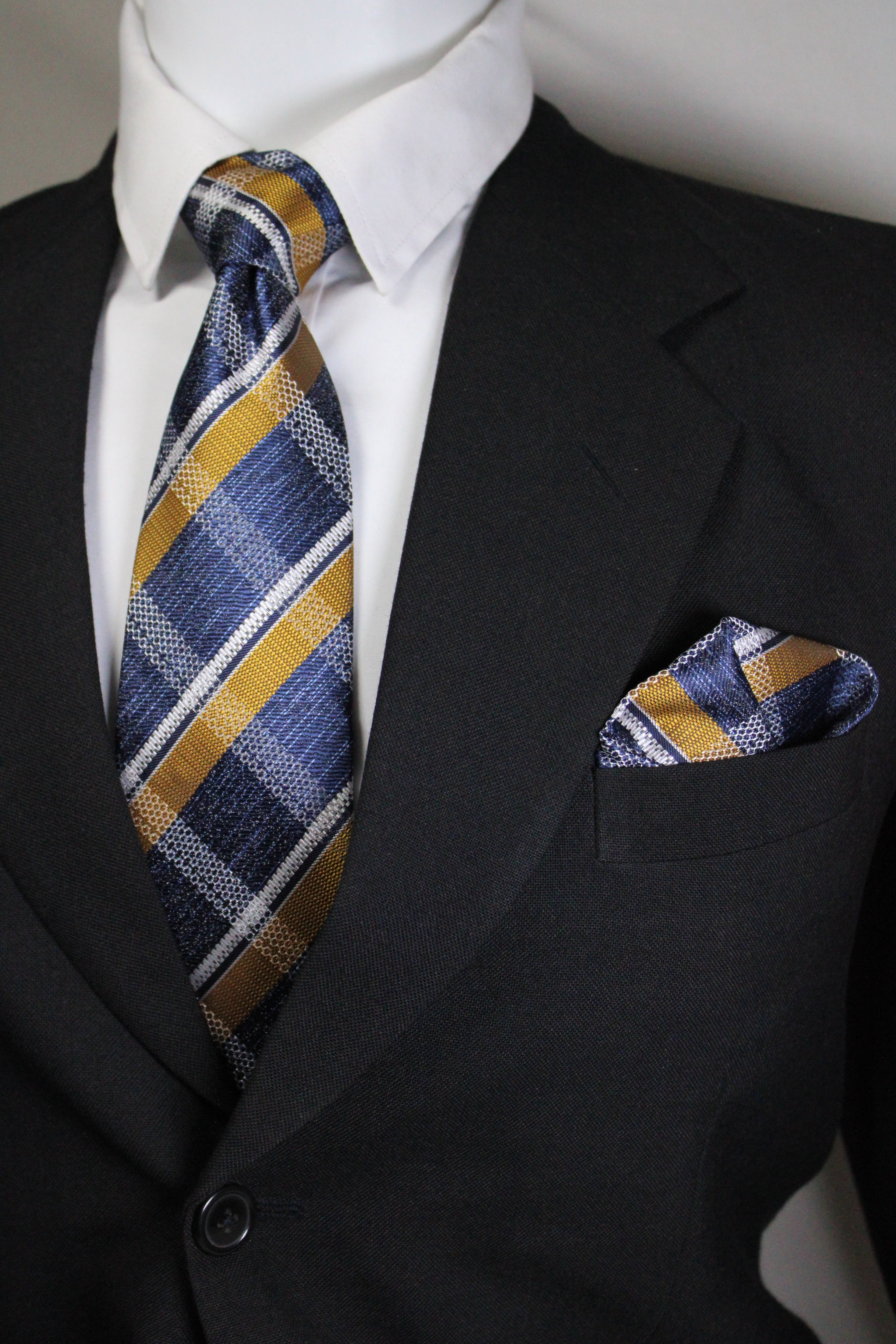 Striped tie hanging out of a suit pocket with a white shirt underneath Tie Benon