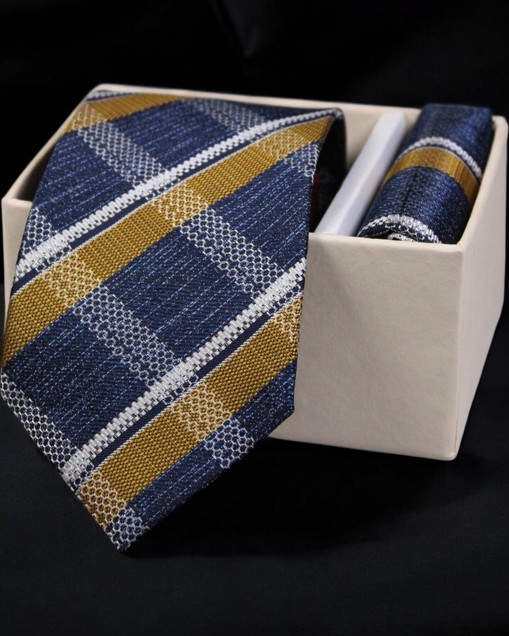 Blue and gold striped tie with matching pocket square in a white box on a black background