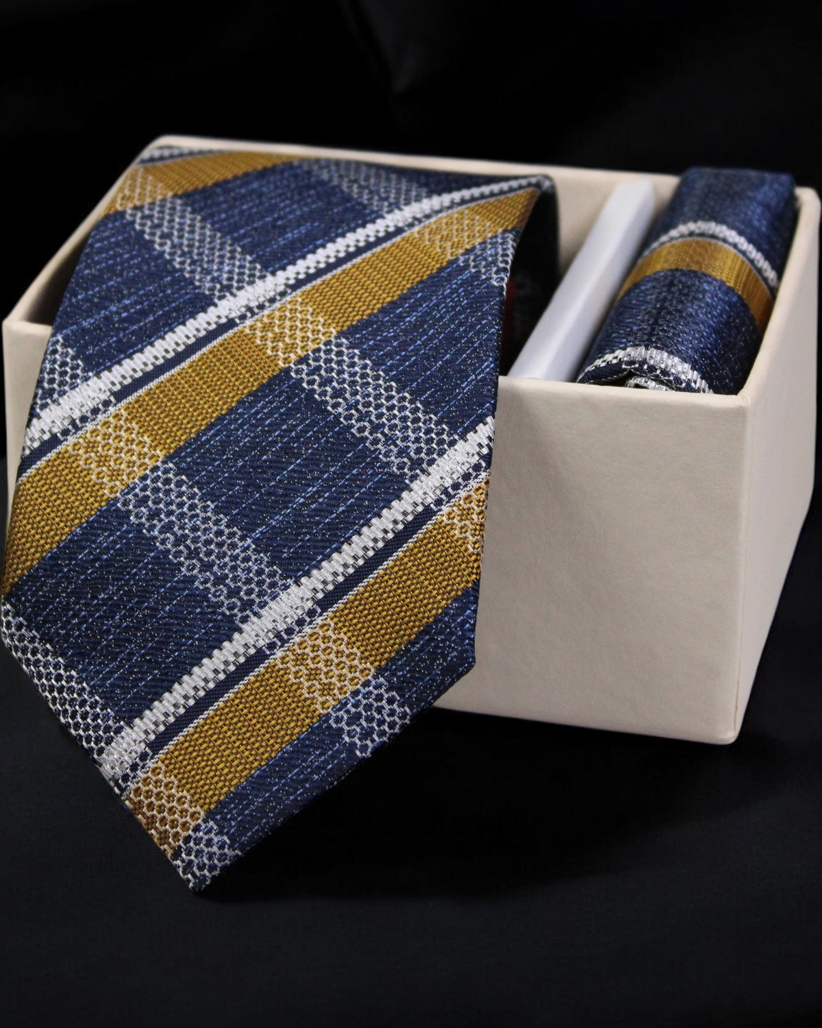 Blue and gold striped tie with matching pocket square in a white box on a black background