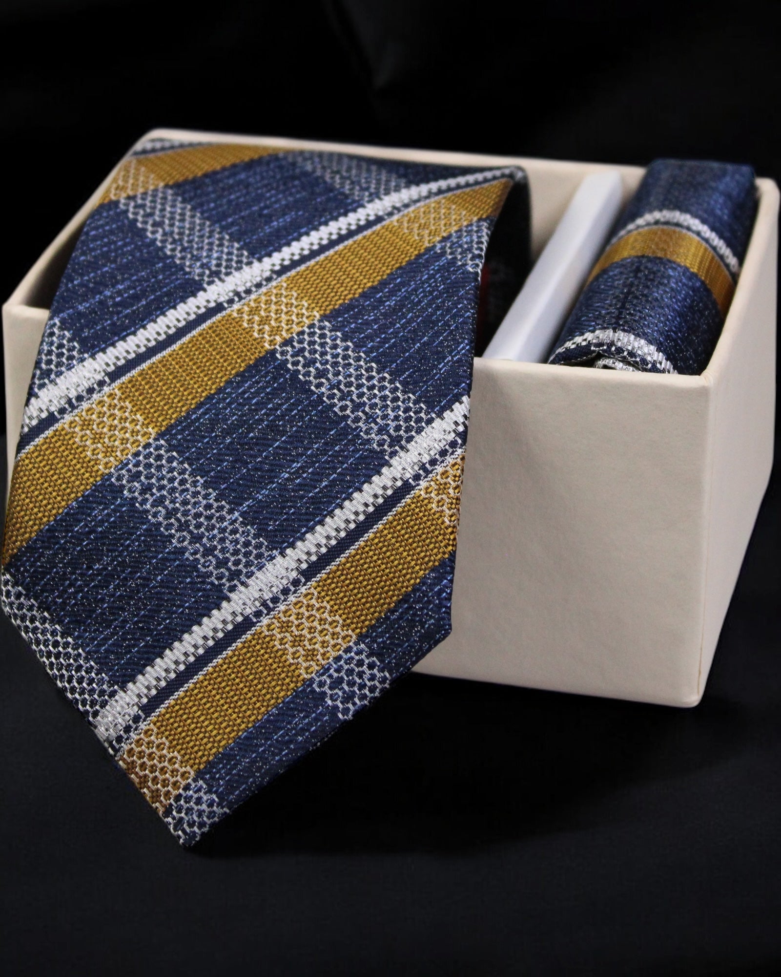 Blue and gold striped tie with matching pocket square in a white box on a black background