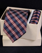Navy and red plaid tie and pocket square set in a white box on a black background Tie Benon