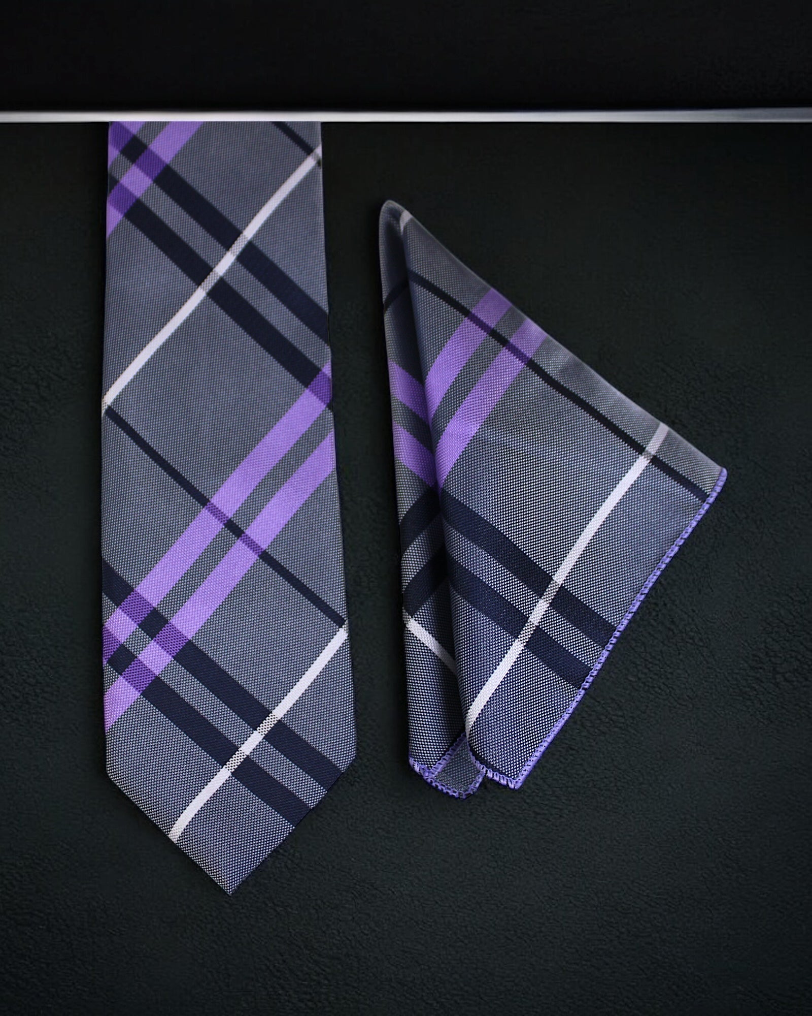 Plaid tie and pocket square set on a black background