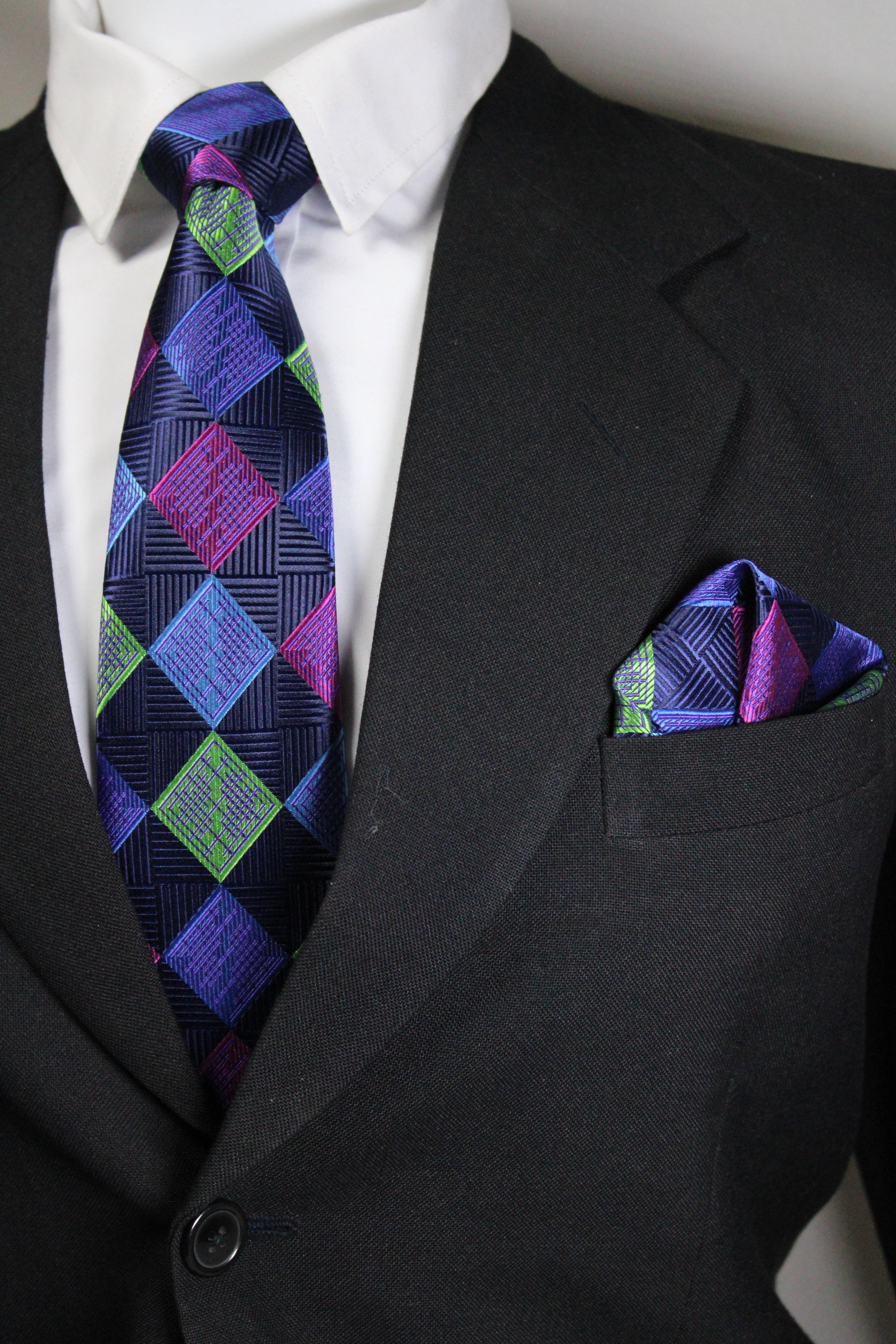 Close-up of a suit with a patterned tie and pocket square Tie benon
