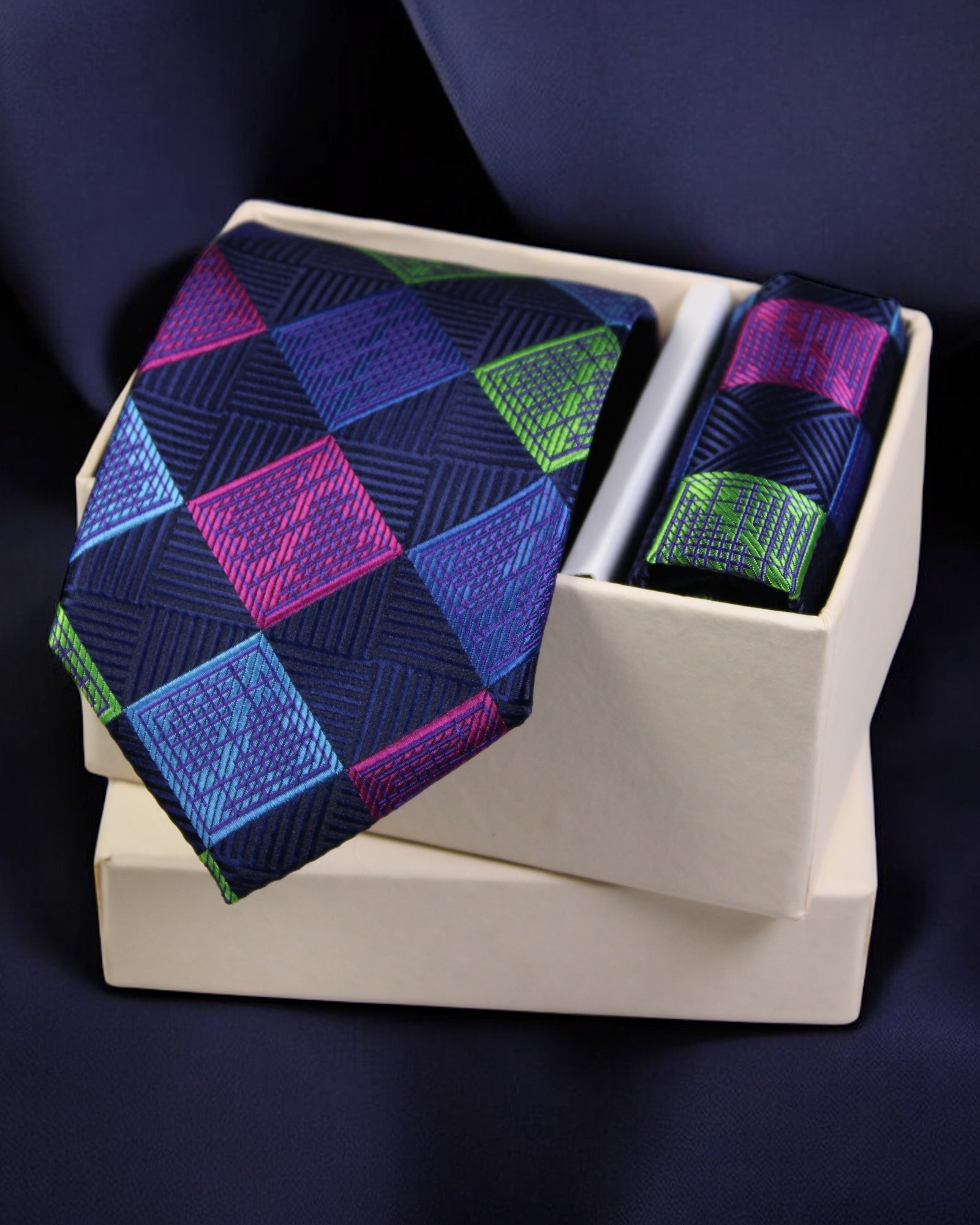 Colorful geometric patterned tie and pocket square set on a white stand against a dark background Tie Benon