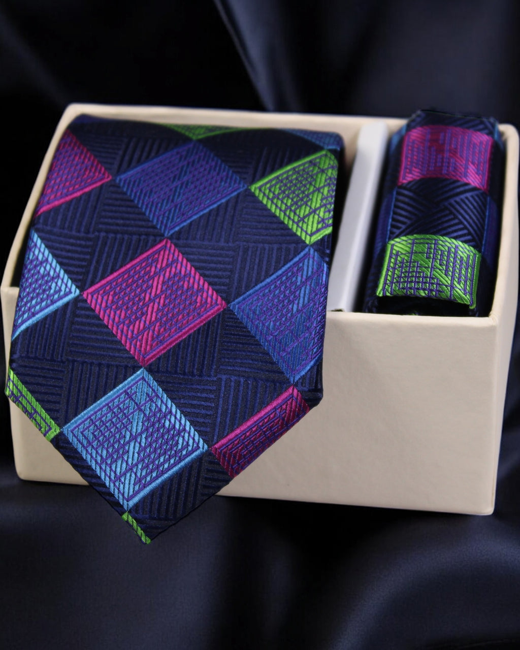 Navy tie with colorful geometric pattern in a white box on a dark background Tie Benon