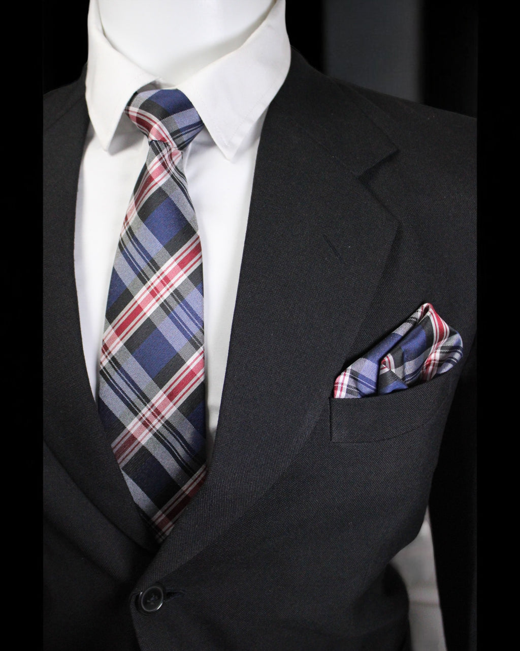 Black suit with plaid tie and pocket square on a mannequin against a black background Tie Benon