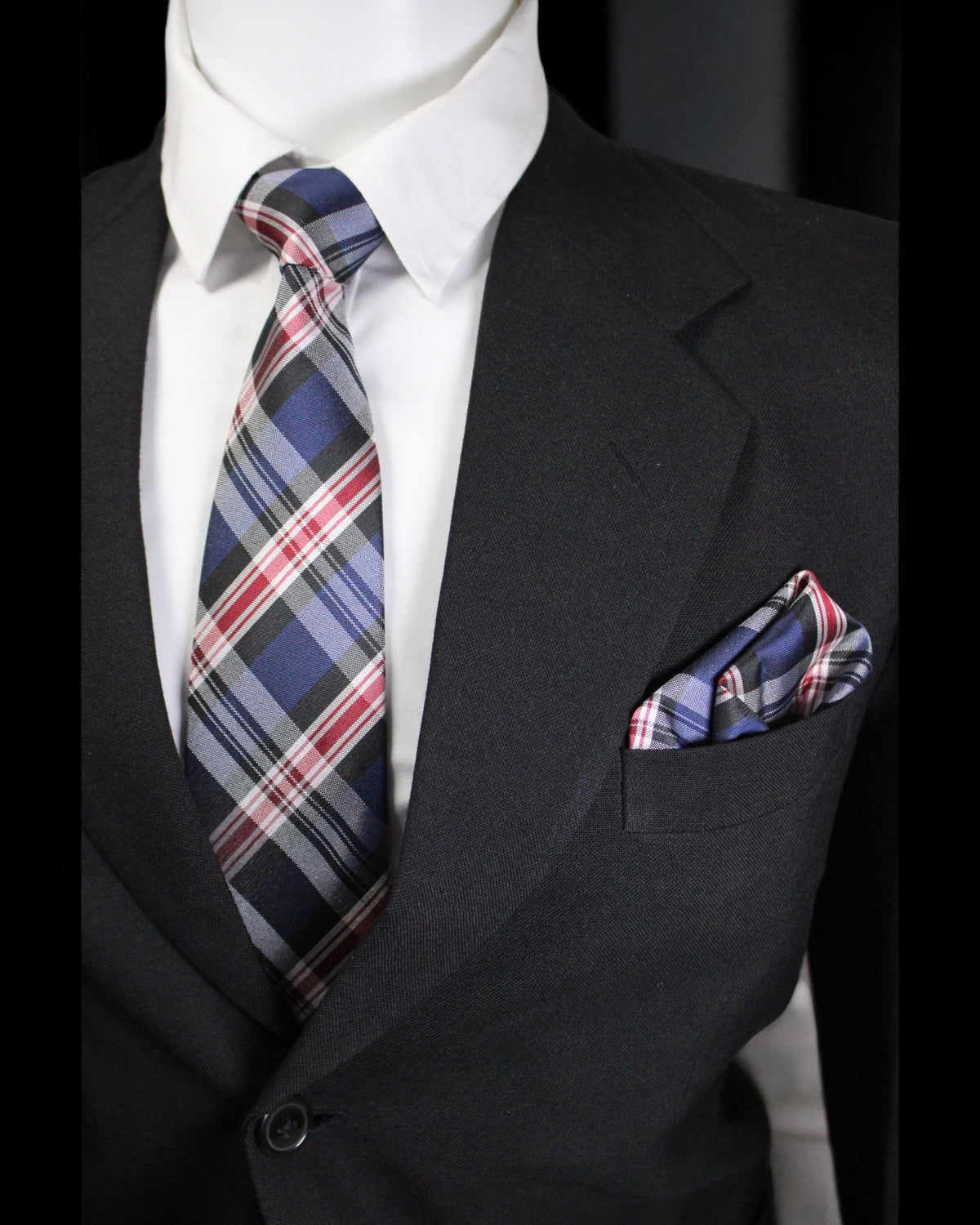 Black suit with plaid tie and pocket square on a mannequin against a black background Tie Benon