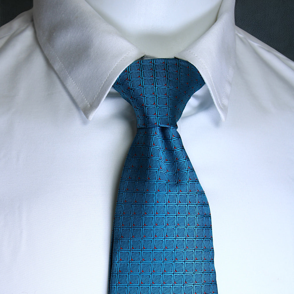 Blue patterned tie on a white shirt against a black background