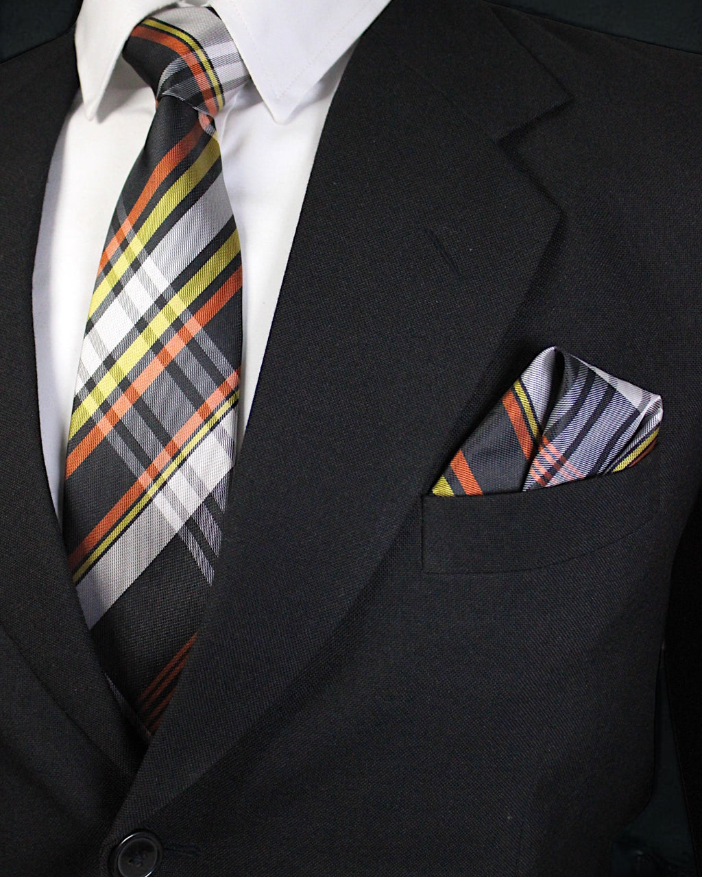 Black suit with a plaid tie and pocket square on a dark background Tie Benon