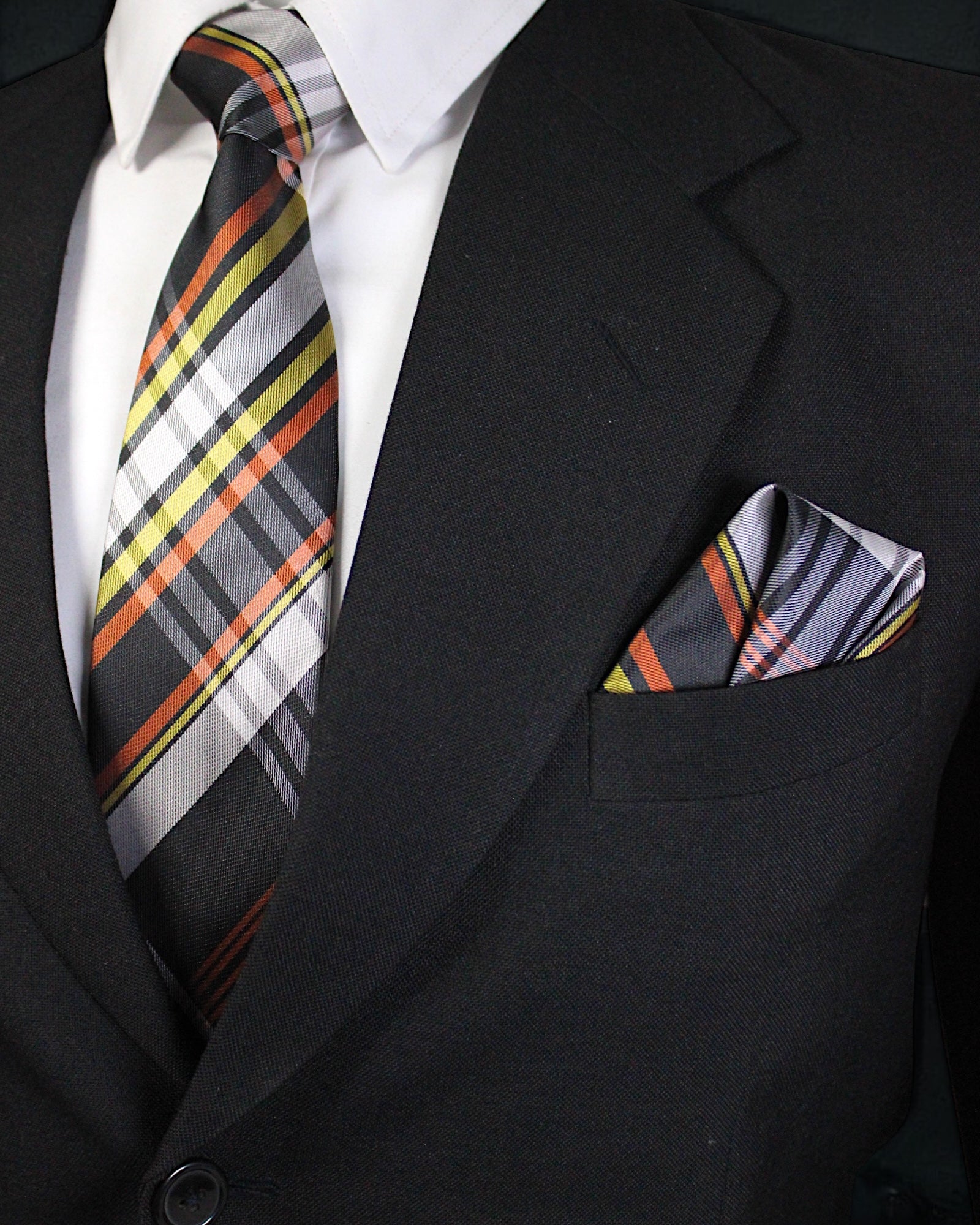 Black suit with a plaid tie and pocket square on a dark background Tie Benon