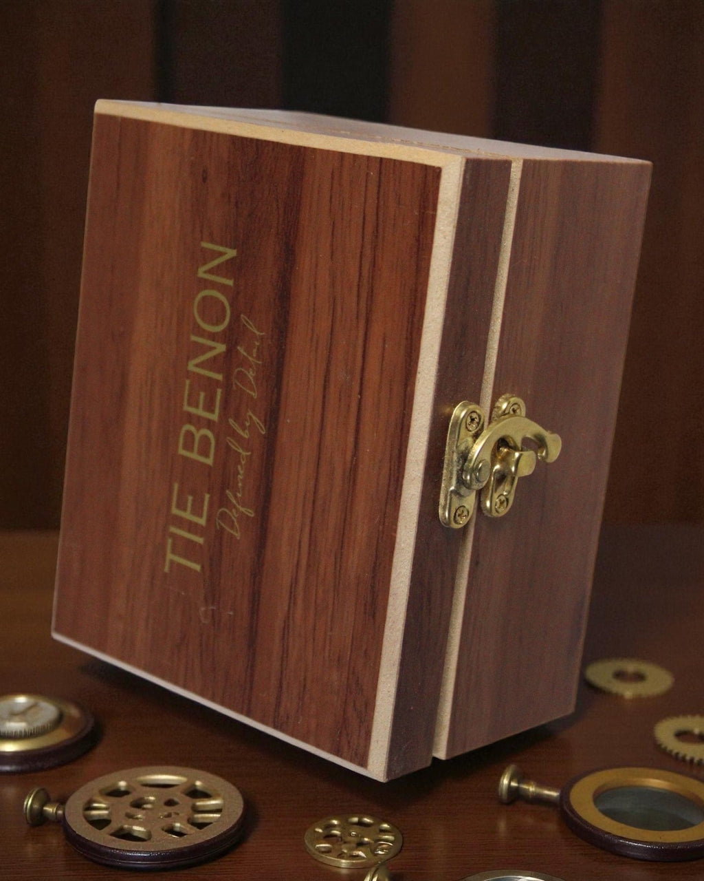 Wooden box with 'Tie Benon' engraving on a wooden surface with mechanical components.