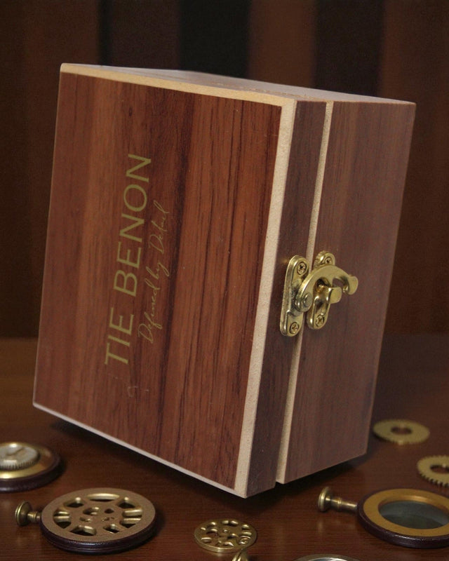 Wooden box with 'Tie Benon' engraving on a wooden surface with mechanical components.