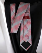 Pink and gray checkered tie with a red label on a black background
