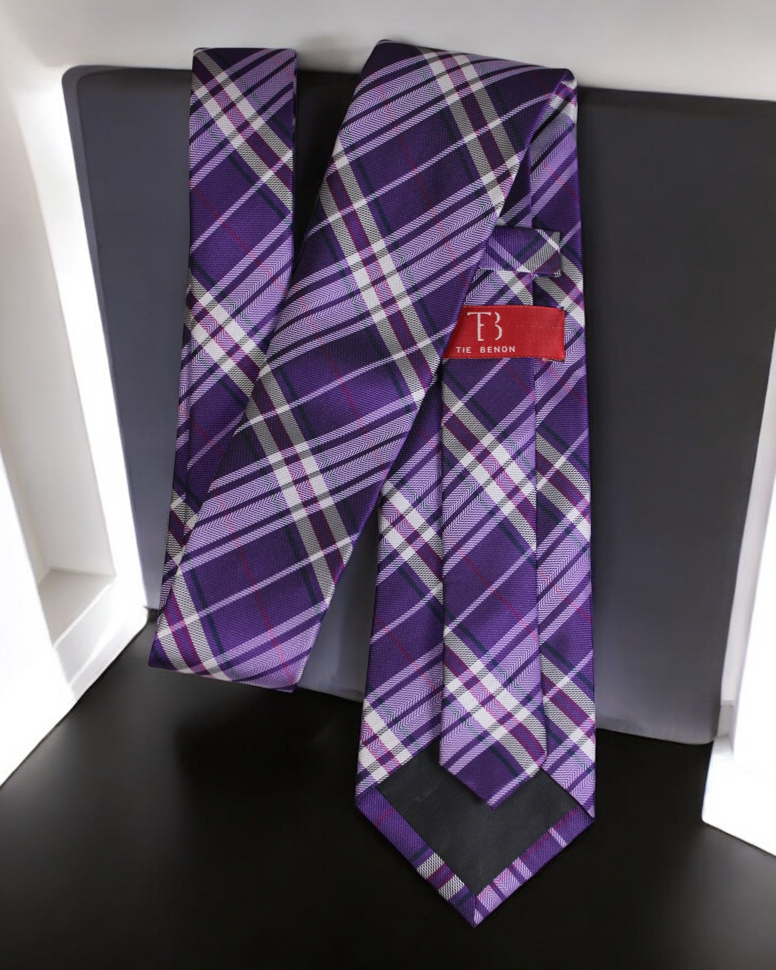 Purple plaid tie with a red label on a black surface Tie Benon