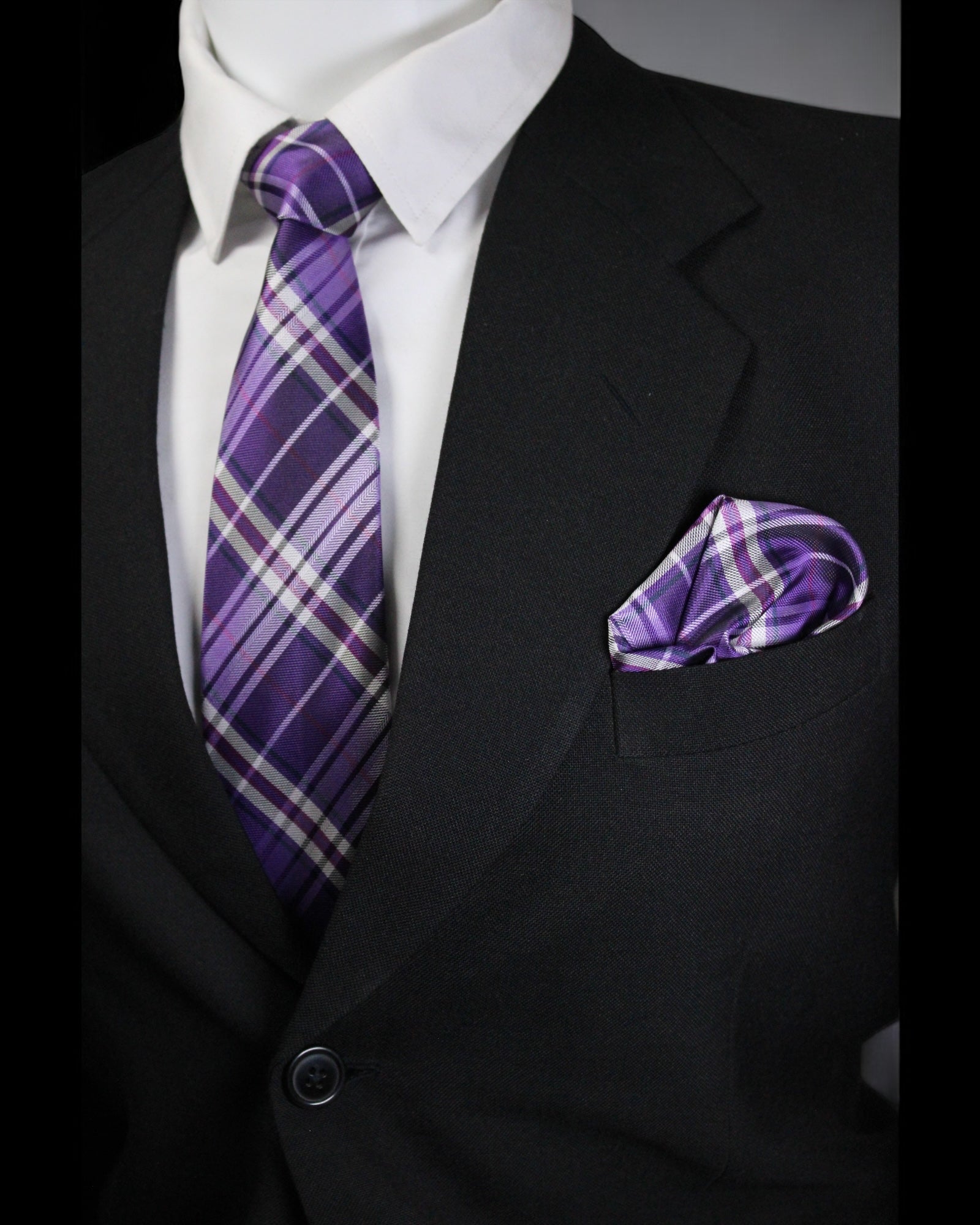 Black suit with a white shirt, purple plaid tie, and matching pocket square tie benon