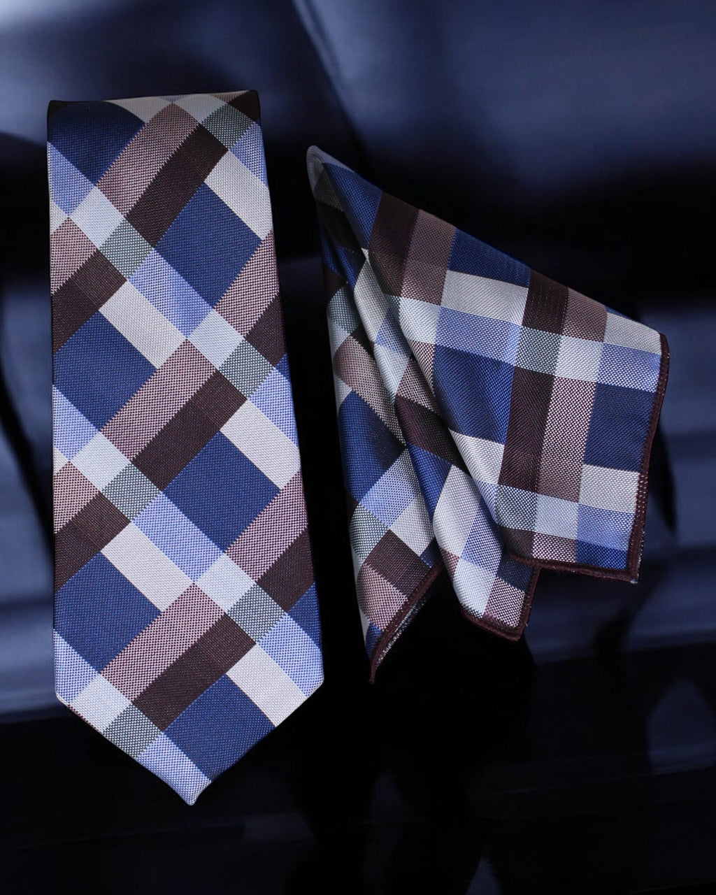 Plaid tie and pocket square set on a dark background