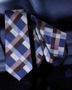 Plaid tie and pocket square set on a dark background
