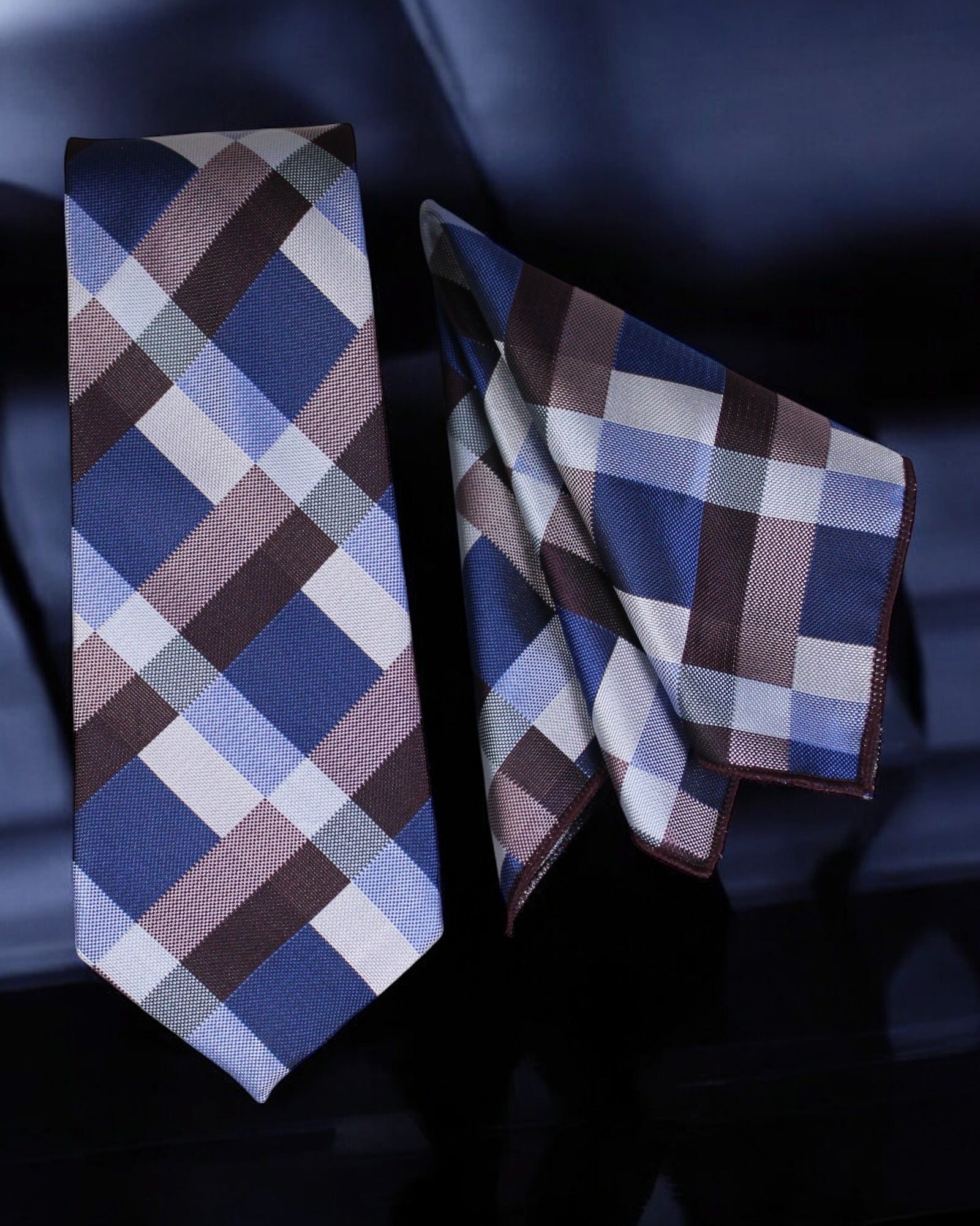 Plaid tie and pocket square set on a dark background