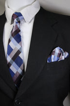 Close-up of a suit with a plaid tie and pocket square.