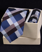 Plaid tie and pocket square set in a box on a black background