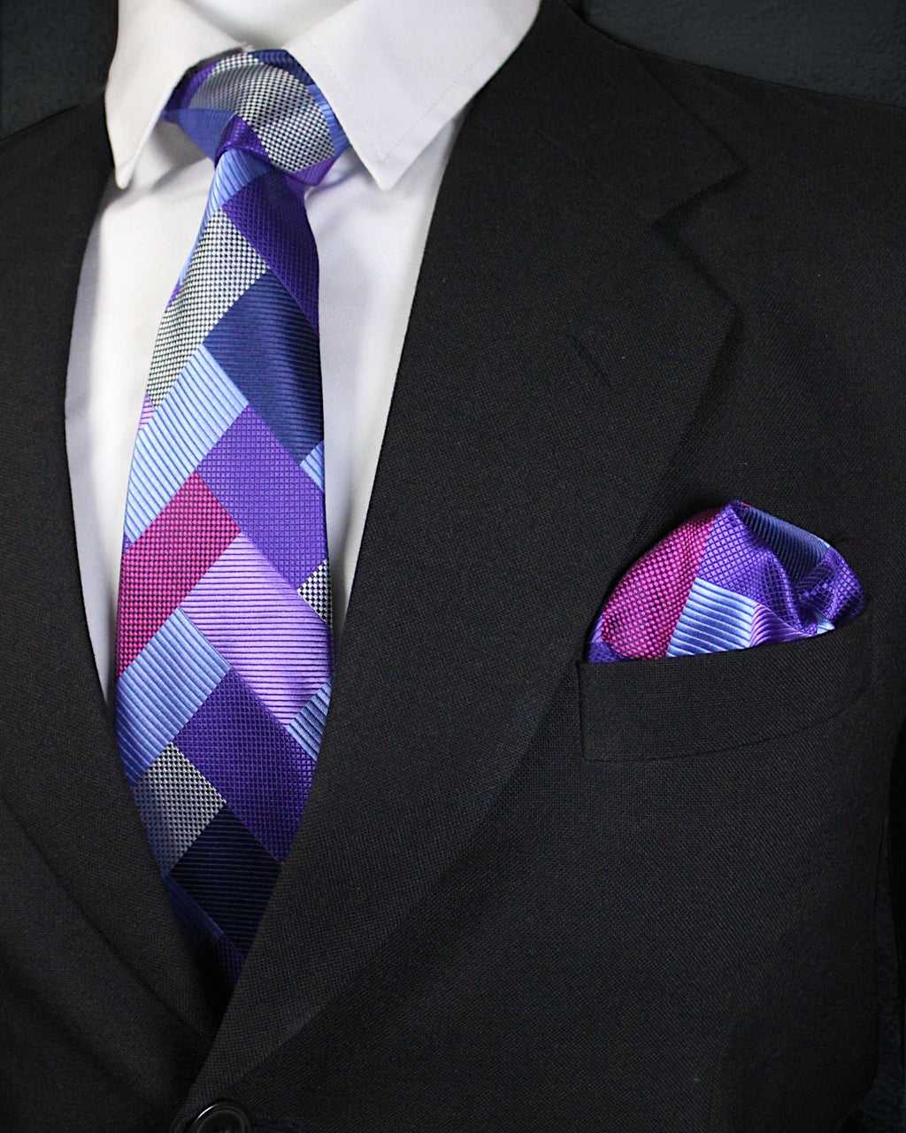 Black suit with a patterned purple tie and pocket square Tie Benon