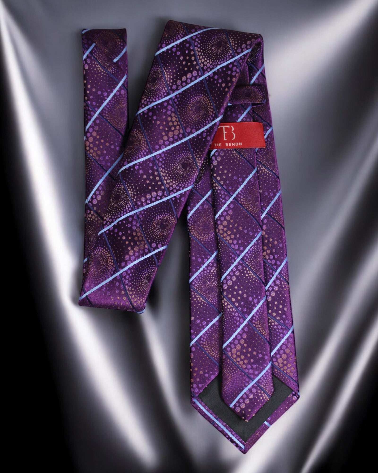 Purple patterned tie with a brand label on a silver satin background Tie Benon