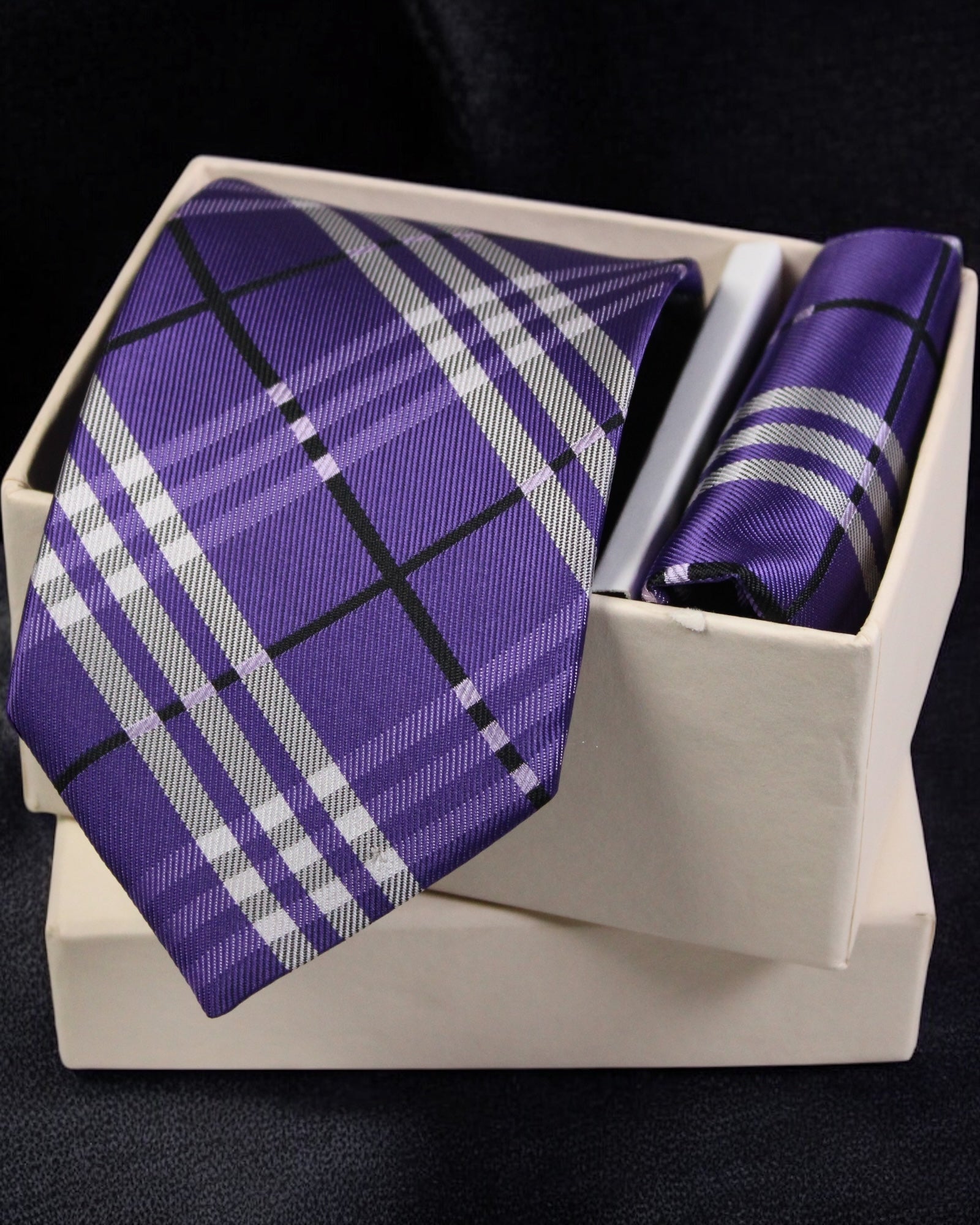 Purple plaid tie and matching pocket square in a white box on a black background Tie Benon