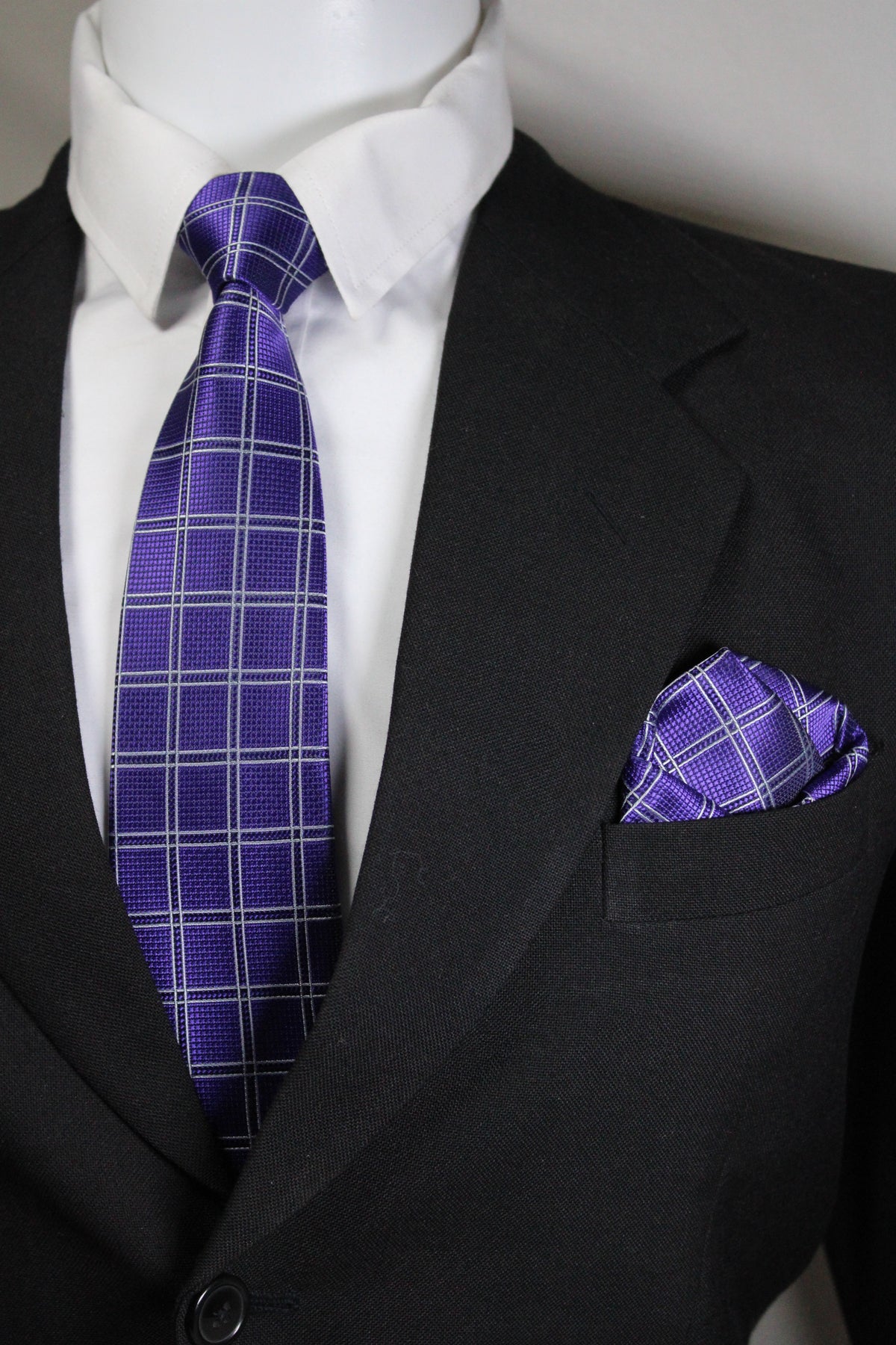 Close-up of a purple plaid tie and pocket square on a black suit jacket Tie Benon