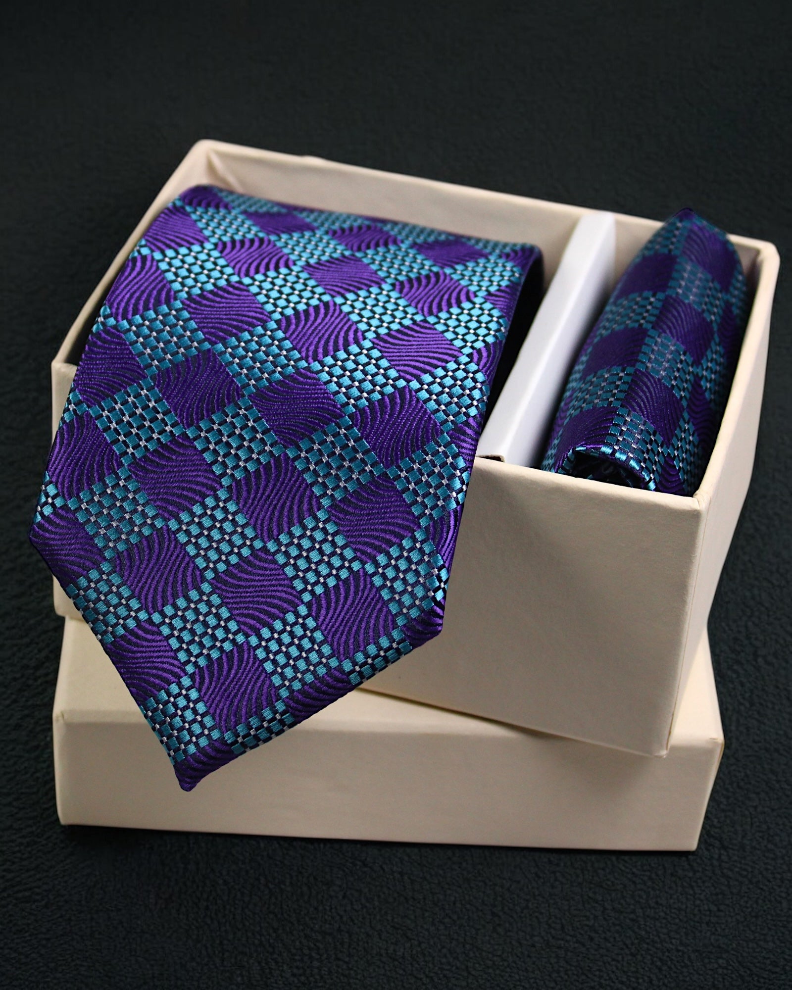 Blue and purple patterned tie and pocket square set in a white box on a black background tie Benon