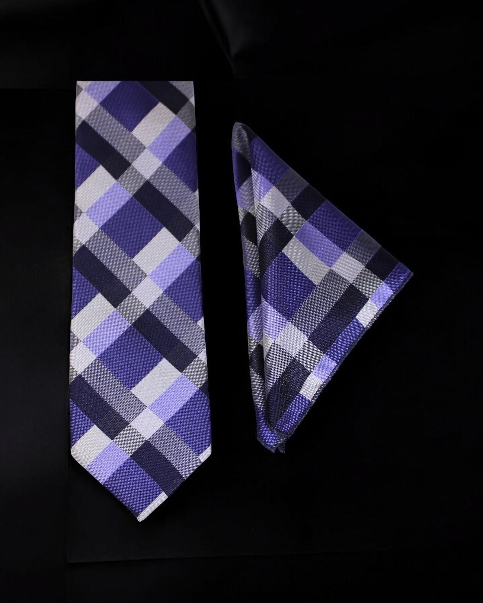 Plaid tie and pocket square set on a black background
