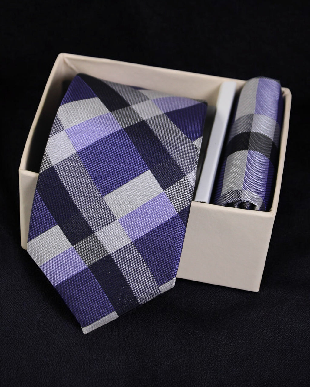 Plaid tie and pocket square set in a white box on a black background