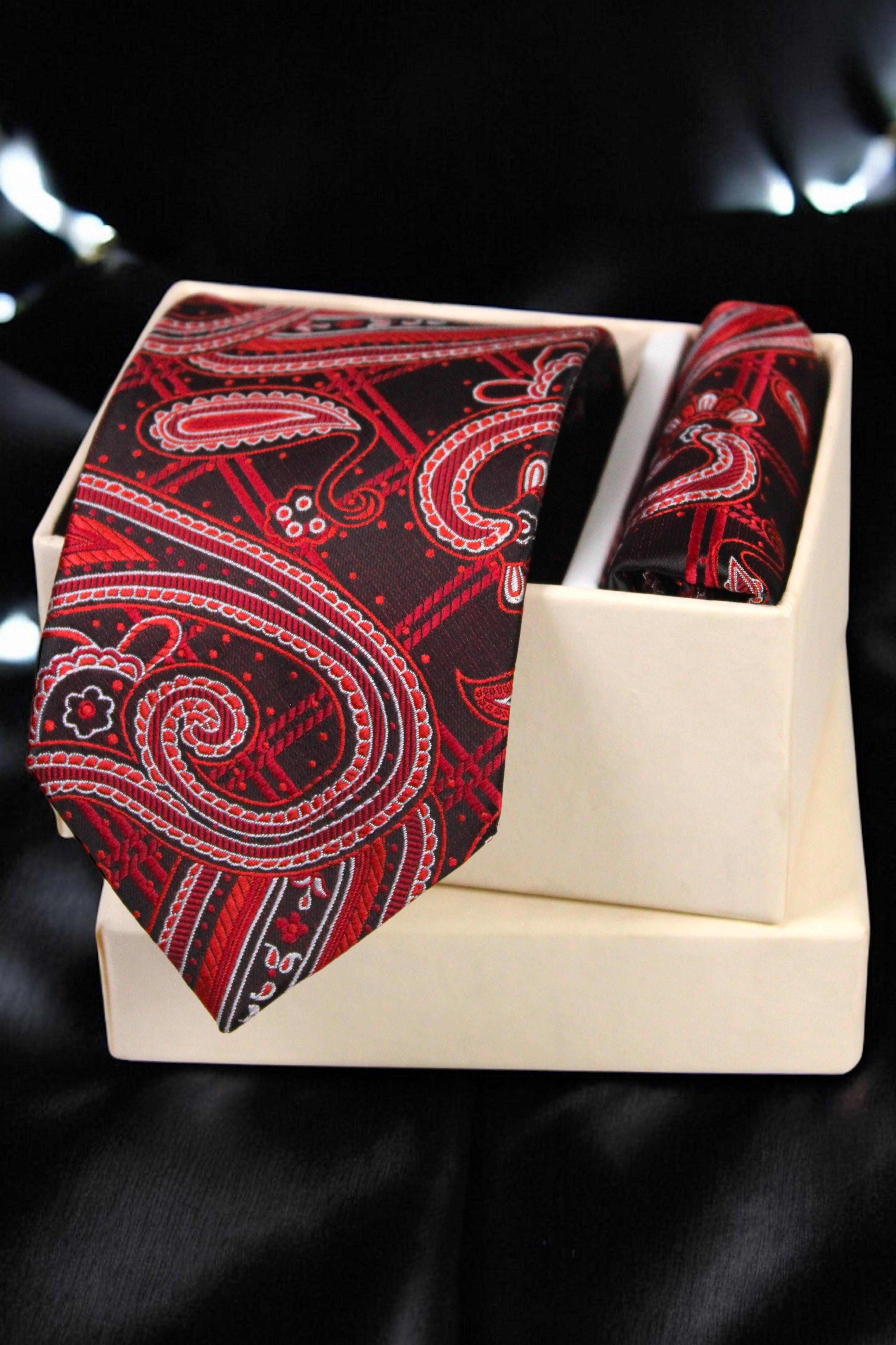 Red paisley tie and matching pocket square on a black background