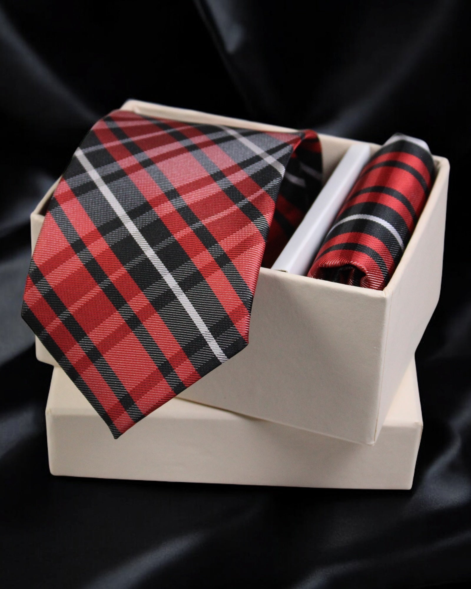 Red and black plaid tie and pocket square set in a white box on a black background Tie Benon