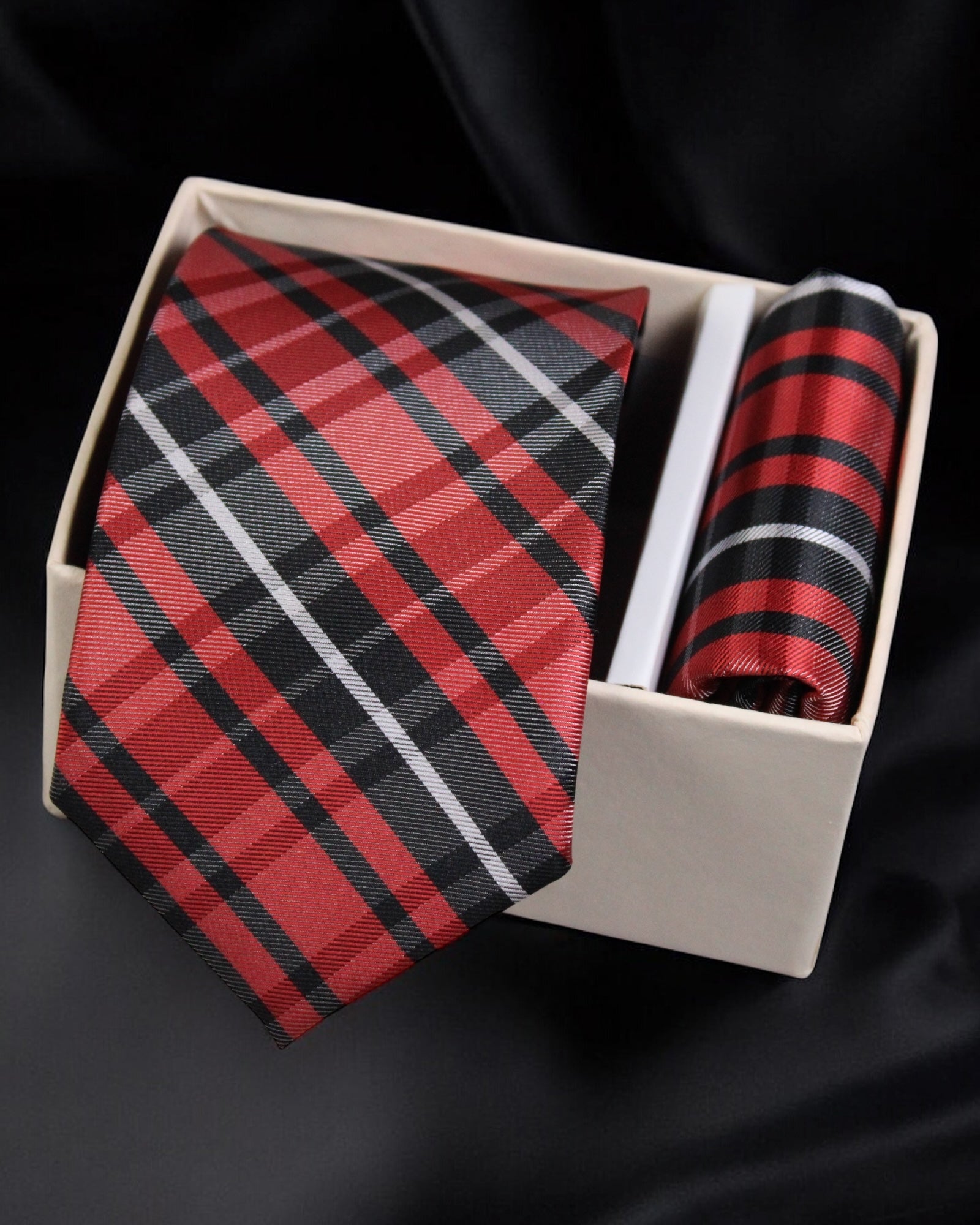 Red and black plaid tie and pocket square set in a box on a black background Tie Benon