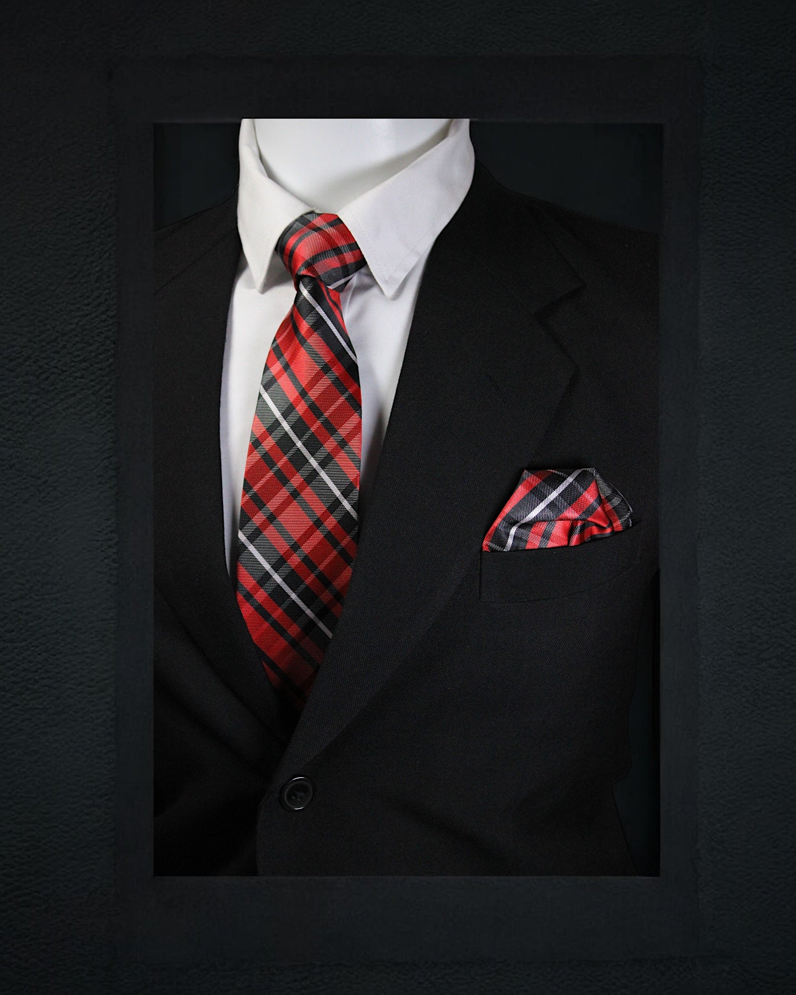 Black suit with a red and black plaid tie and pocket square on a dark background Tie Benon