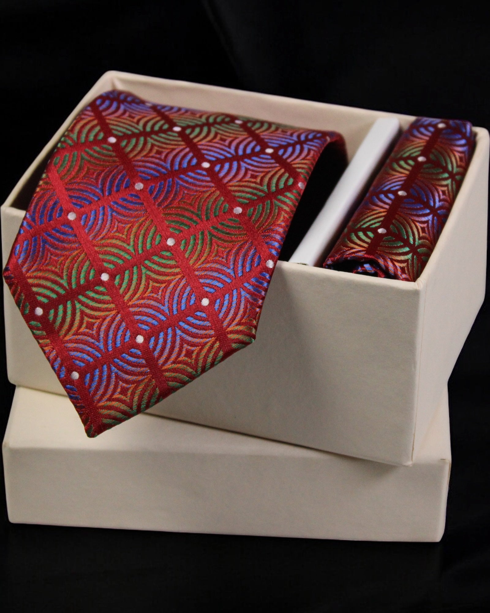 Colorful patterned tie and matching pocket square in a white box on a black background Tie Benon