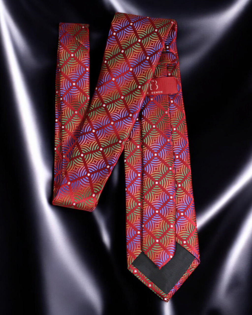Red patterned tie on a reflective black surface Tie Benon