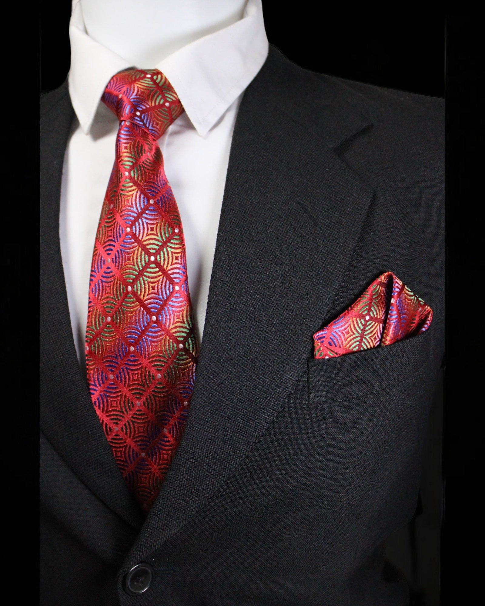 Black suit with a red patterned tie and pocket square on a black background Tie Benon